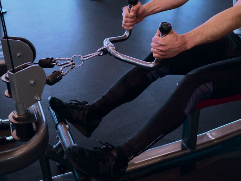 a closeup of a man doing row exercises in the gym