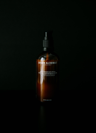 a bottle of dark brown sunscreen in a pitch black room