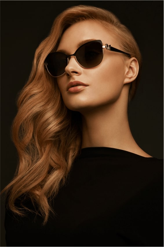Blonde woman with dark sunglasses on black background
