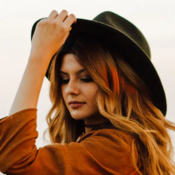 a girl in a hat and a brown coat