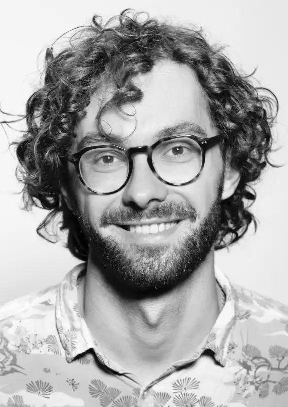 a guy with curly hair and glasses