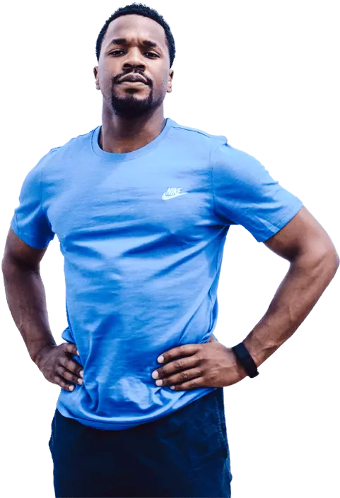 Entrenador deportivo de pelo corto y perilla con camisa azul y pantalones oscuros.