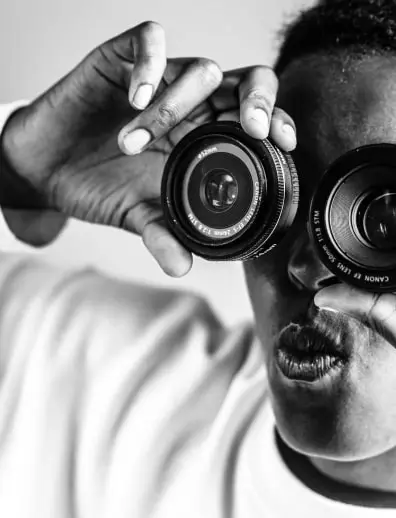 man goofing around using lenses as binoculars