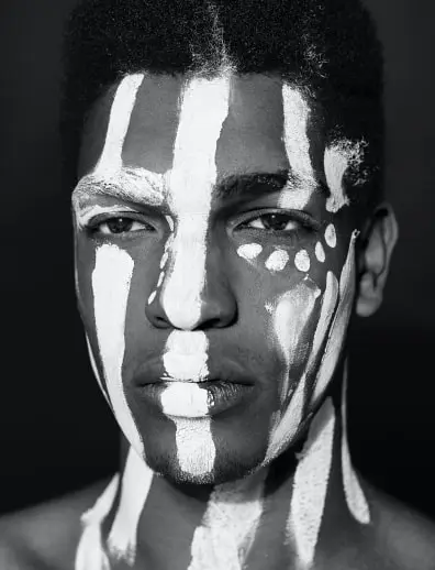 uomo di colore coperto di pittura di guerra tribale bianca