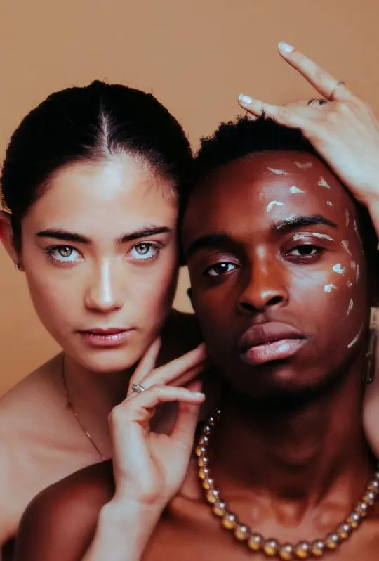 uma mulher e um homem posando para uma foto estilizada coberta de manchas de maquiagem