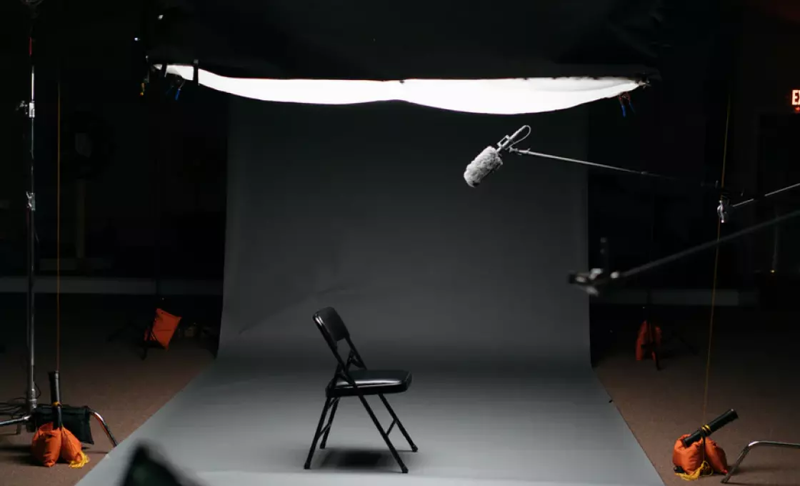 estúdio fotográfico e uma cadeira parada no meio da sala