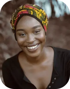 une femme noire avec un bandeau souriant à la caméra