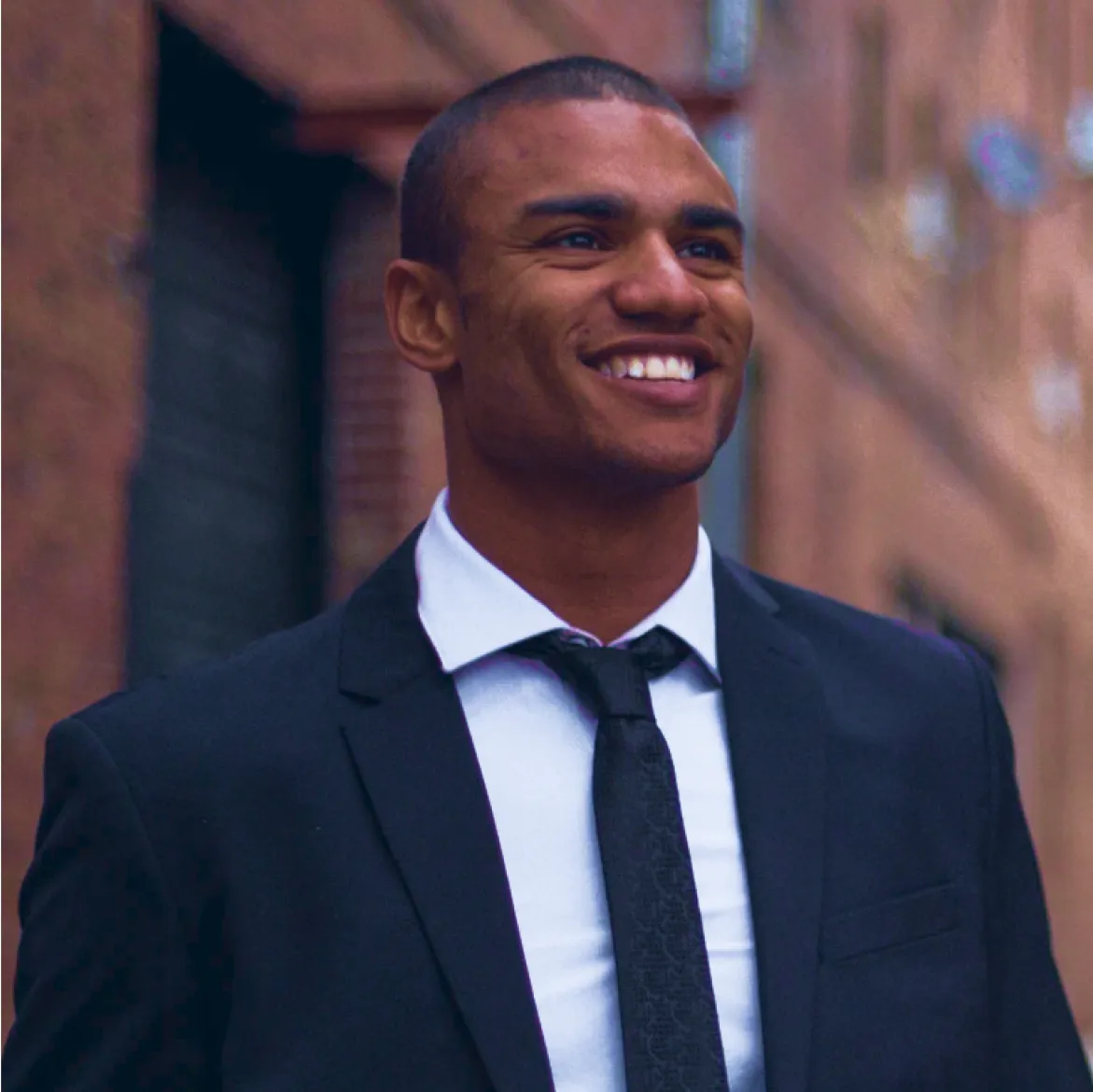 man in a navy blue suit with a tie in an urbanistic scene