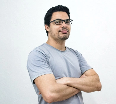 white man with his arms crossed wearing grey shirt and glasses 
