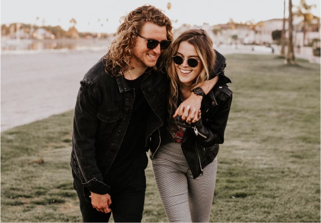 a couple on a walk both wearing black leather jackets and dark sunglasses