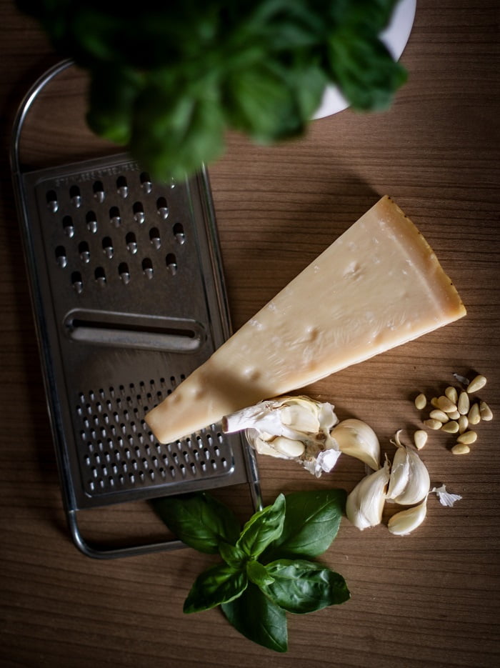 a parmesan cheese with garlic and basil leaves before choping