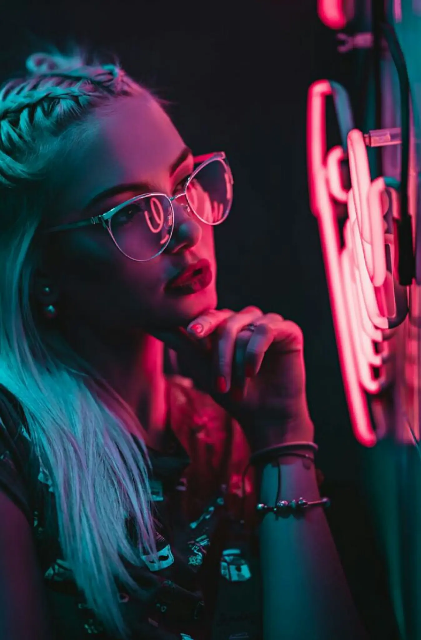 Girl with glasses looks at neon