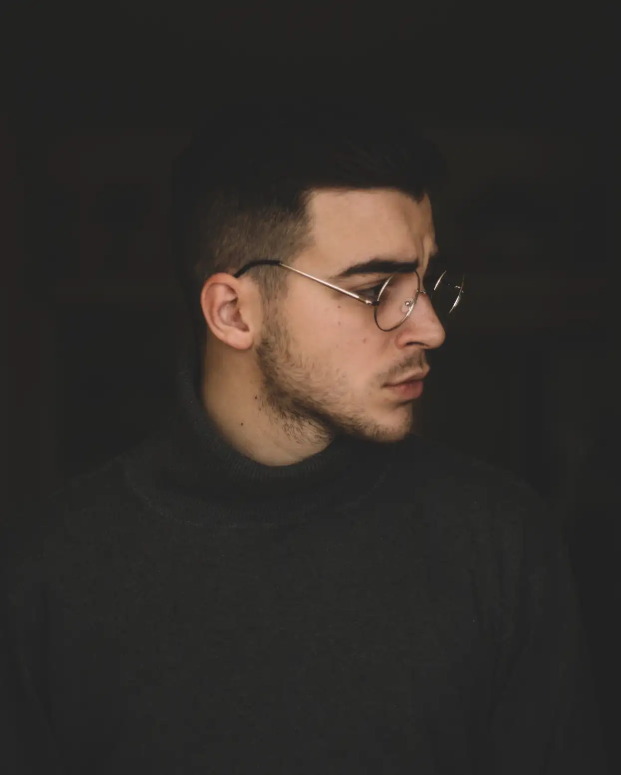 a man with glasses in a black sweater