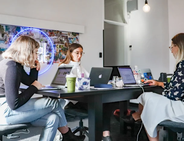 eine Gruppe von Leuten, die ein Problem auf ihrem Laptop besprechen