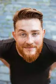 a man with a beard smiles