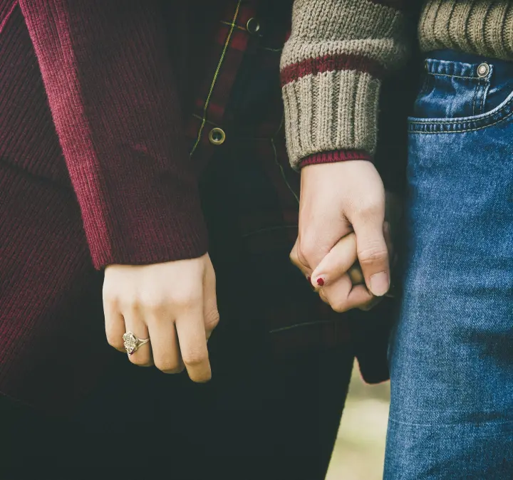 Два человека держатся за руки