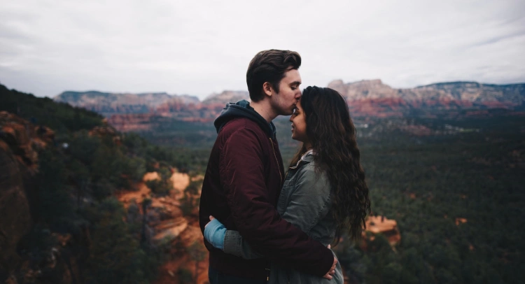 uma foto de duas pessoas abraçadas em uma montanha