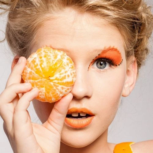 girl holding a tangerine