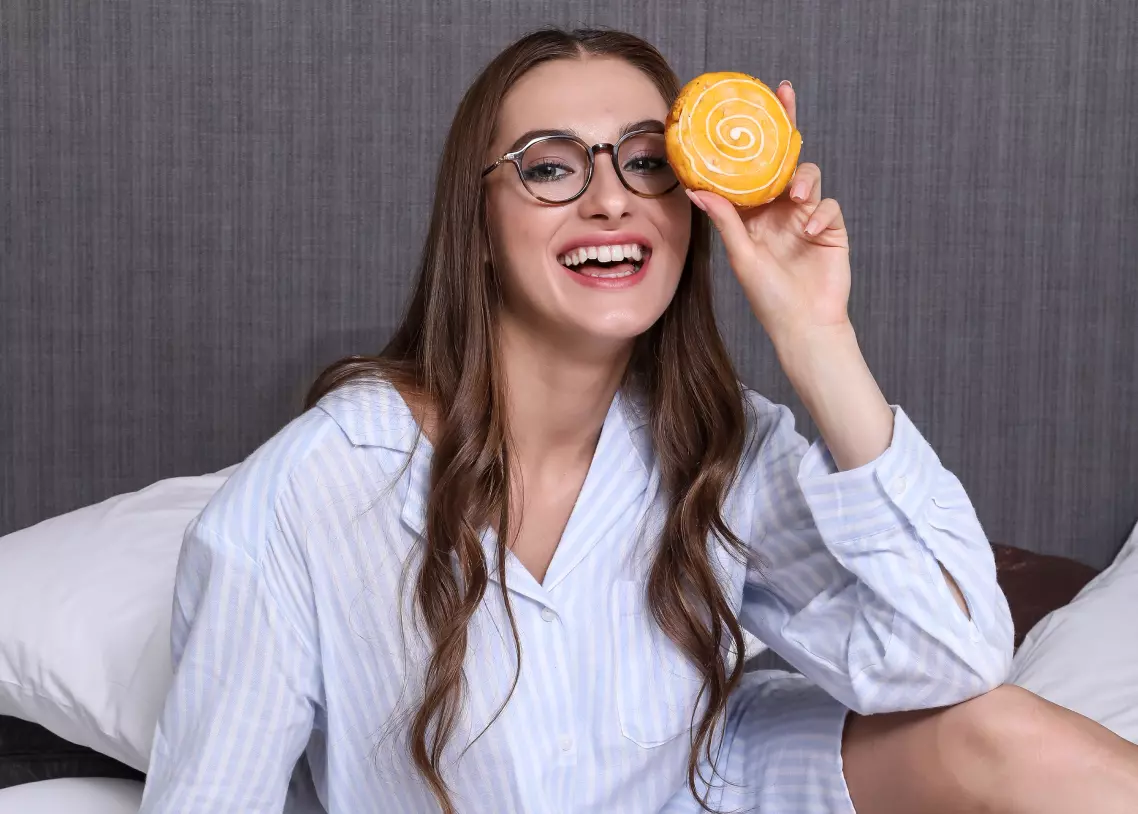 a girl in a shirt holding a cookie