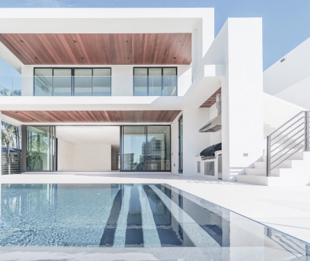 a photo of a white modern house with a pool outside