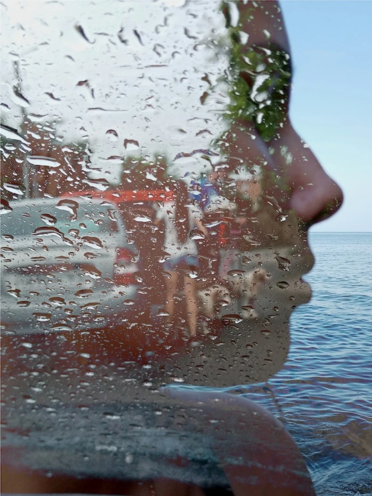 The face of a woman on which another photo can be seen - a woman standing by the car