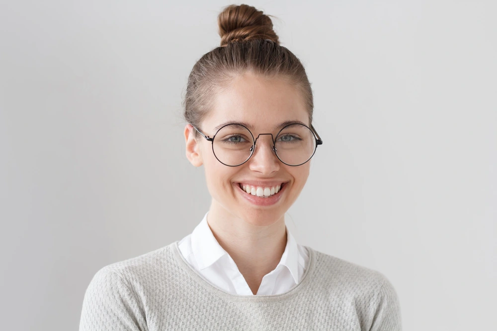 a girl in glasses smiles