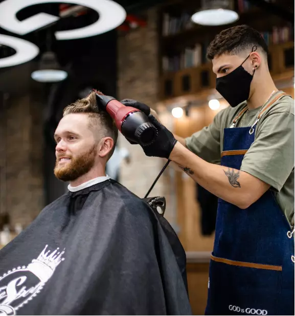 a man in a barbershop gets a haircut