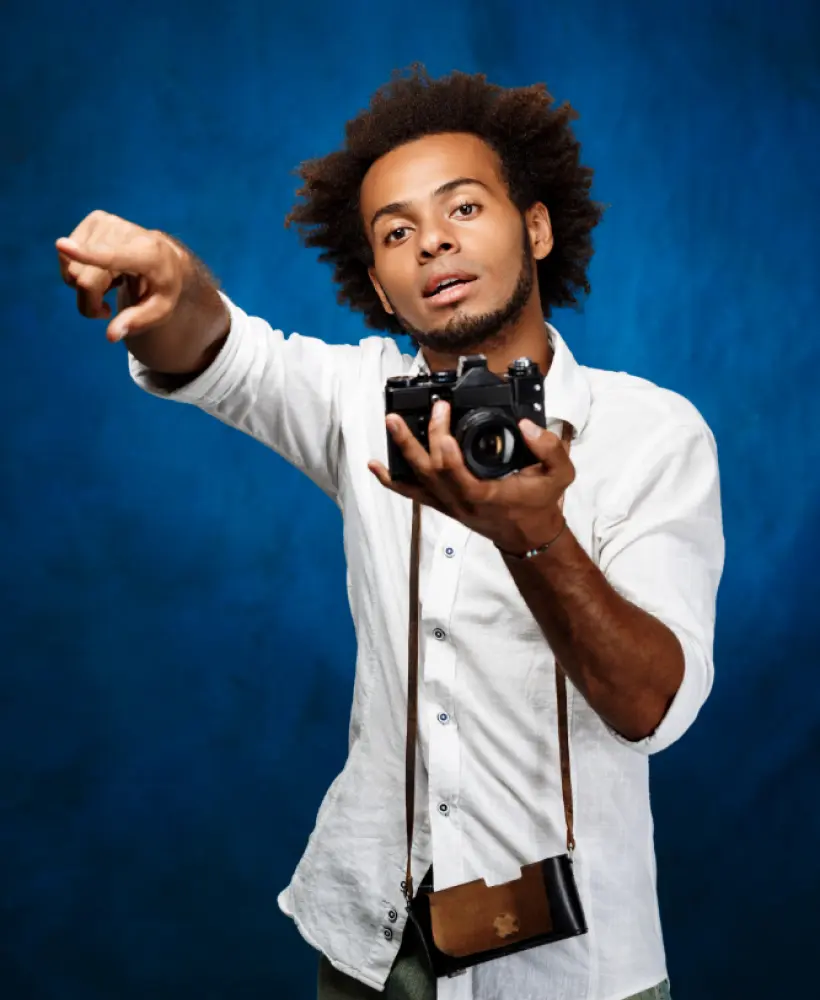 um homem de camisa branca com uma câmera