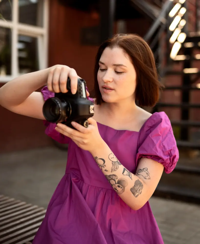 uma garota de vestido com uma câmera