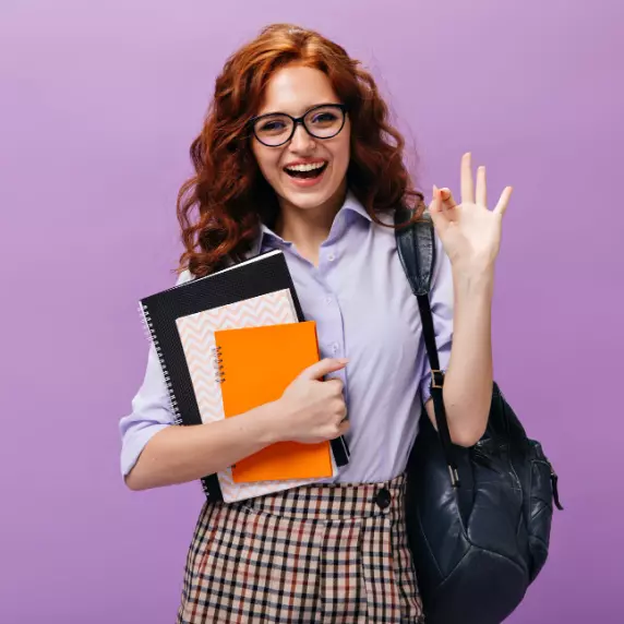 une fille avec un sac et des cahiers à la main