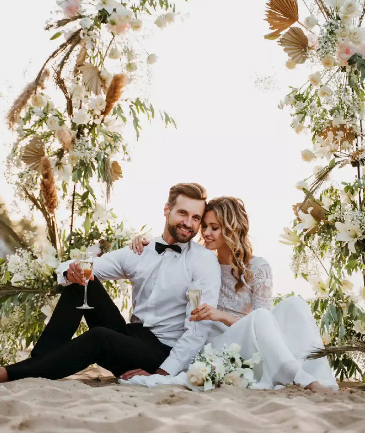 Newlyweds sit on the sand