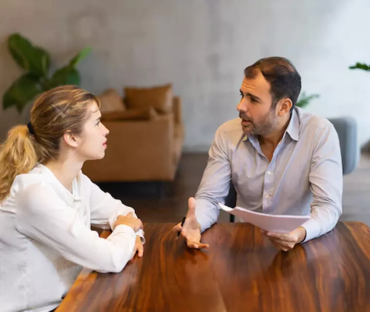 a man and a woman talking at the table 