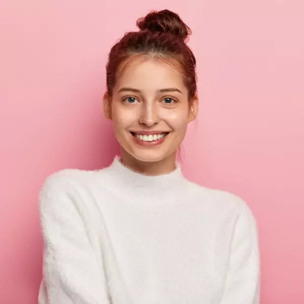 a girl in a white sweater laughs 