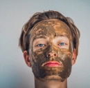 woman wearing a mud facial mask for detox