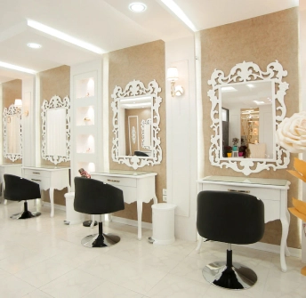 a golden hair salon with white cabinets and hanging mirrors