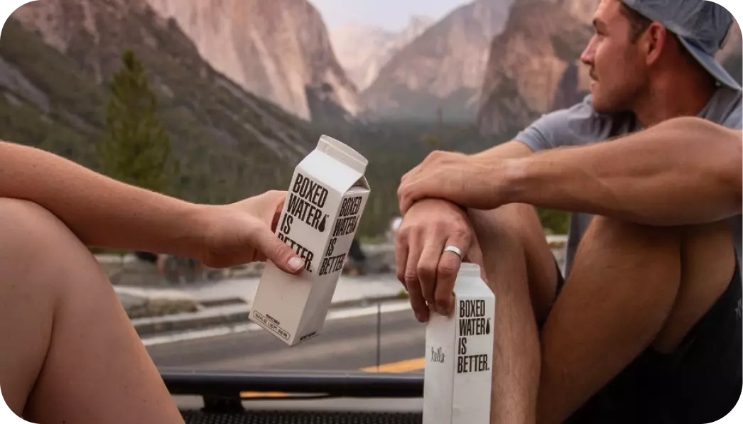 two guys with packs of water in their hands