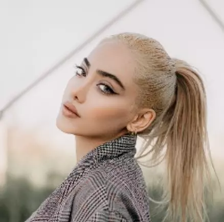 blonde with hair gathered in a ponytail, looking half a turn of her head