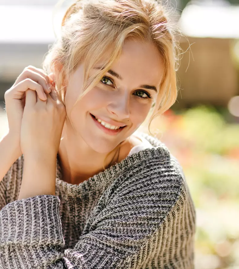 beautiful blonde in a gray sweater, smiling broadly