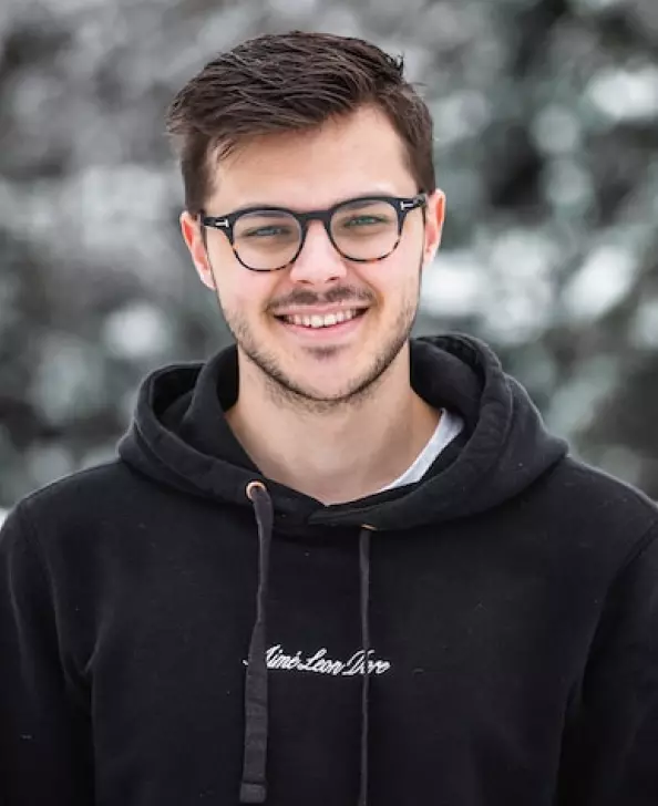 a man in a black sweatshirt and glasses