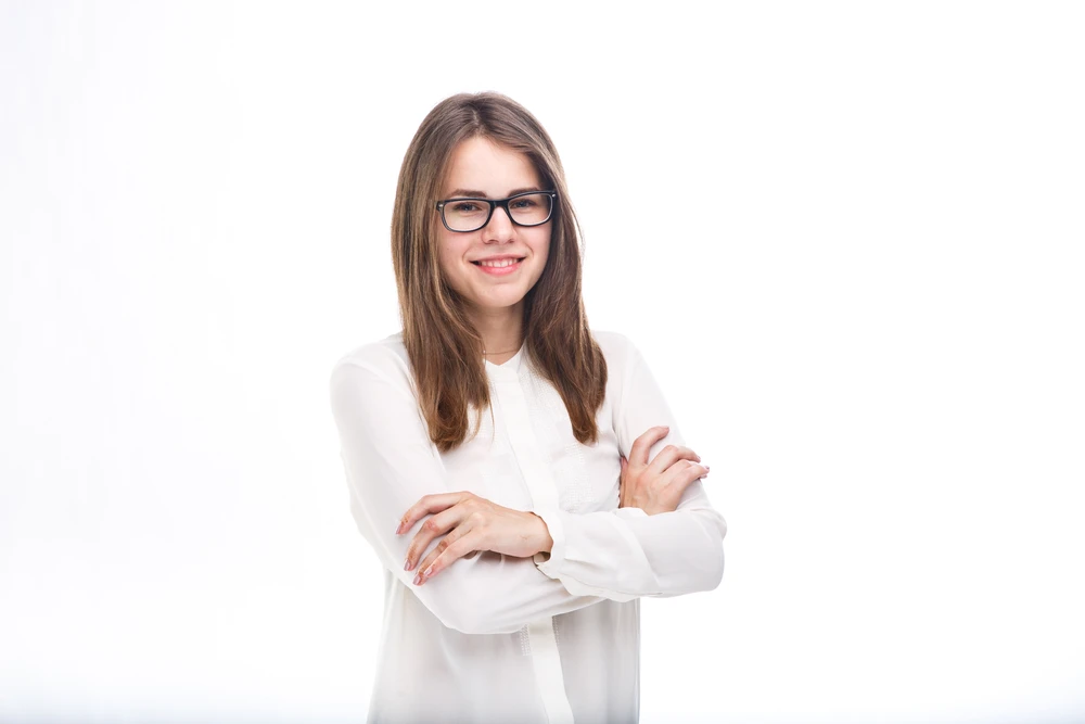 a girl in glasses and a white shirt folded her hands in front of her