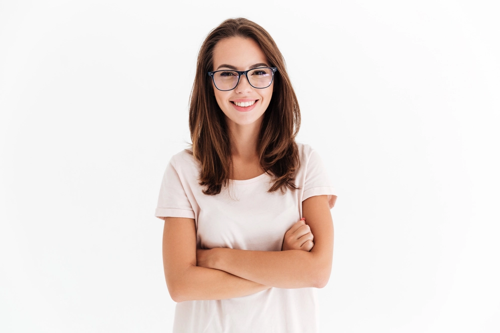 a girl with long brown hair wearing glasses and a white T-shirt folded her arms on her chest