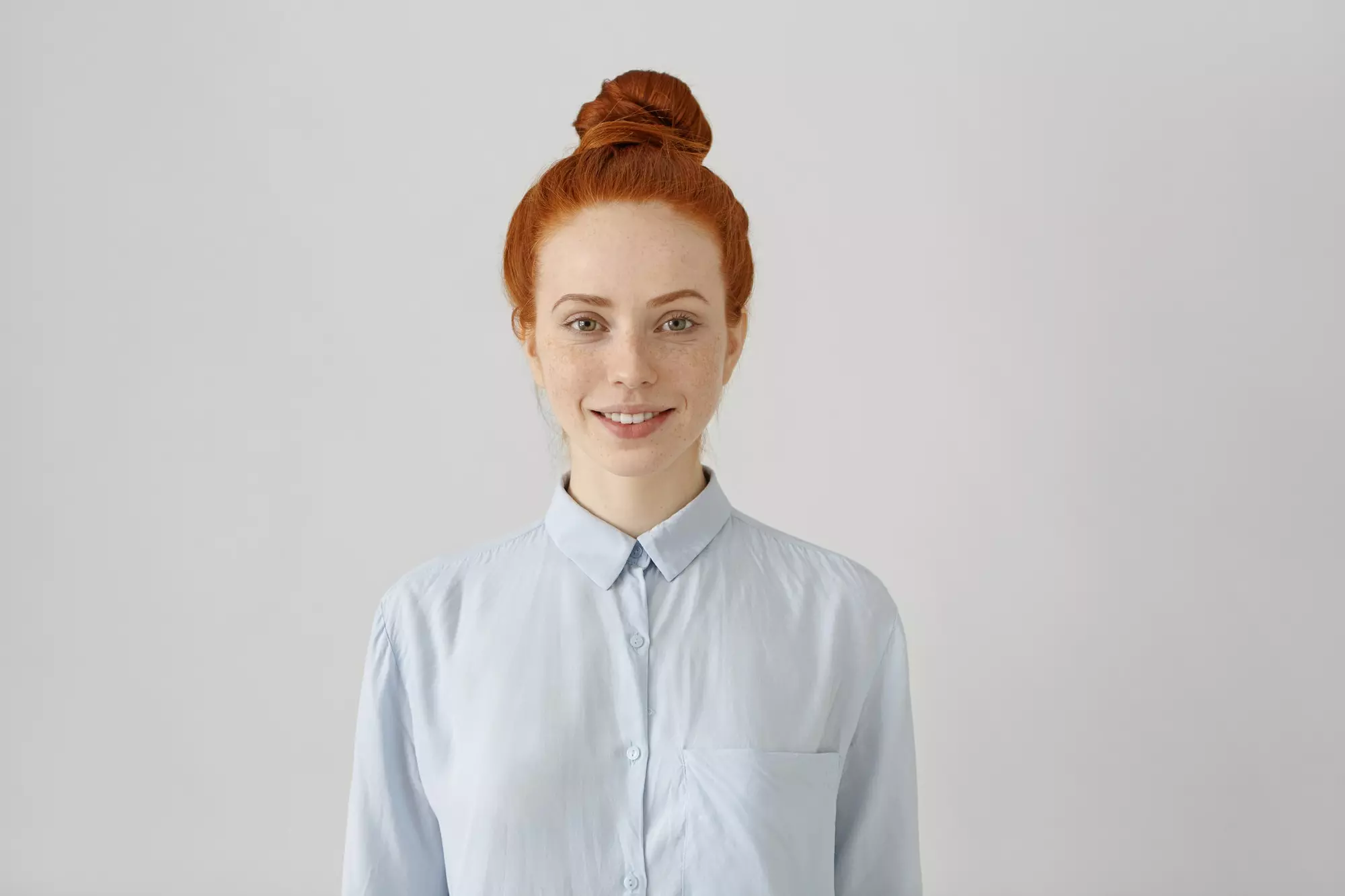 red-haired girl in a white shirt who smiles sweetly