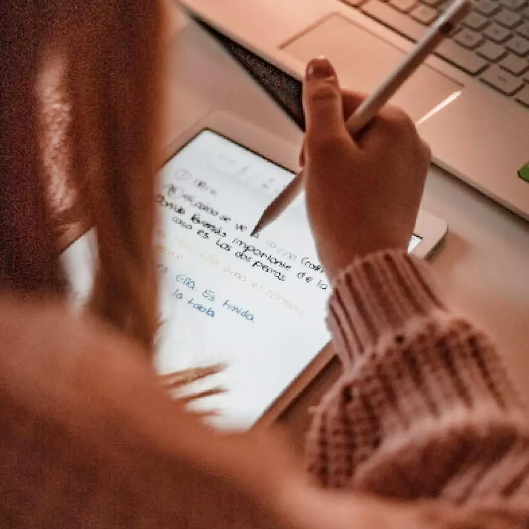 A girl writes with a pen