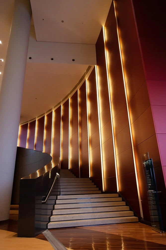 hotel lobby with a high staircase and bright lighting on the walls