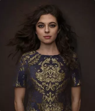 girl with dark wavy hair in a blue dress