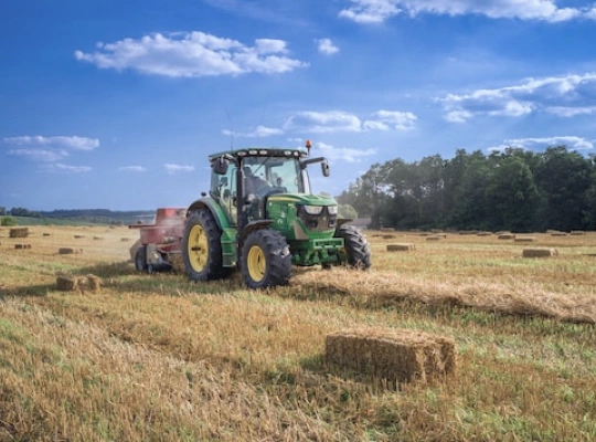 a tractor harvests hay