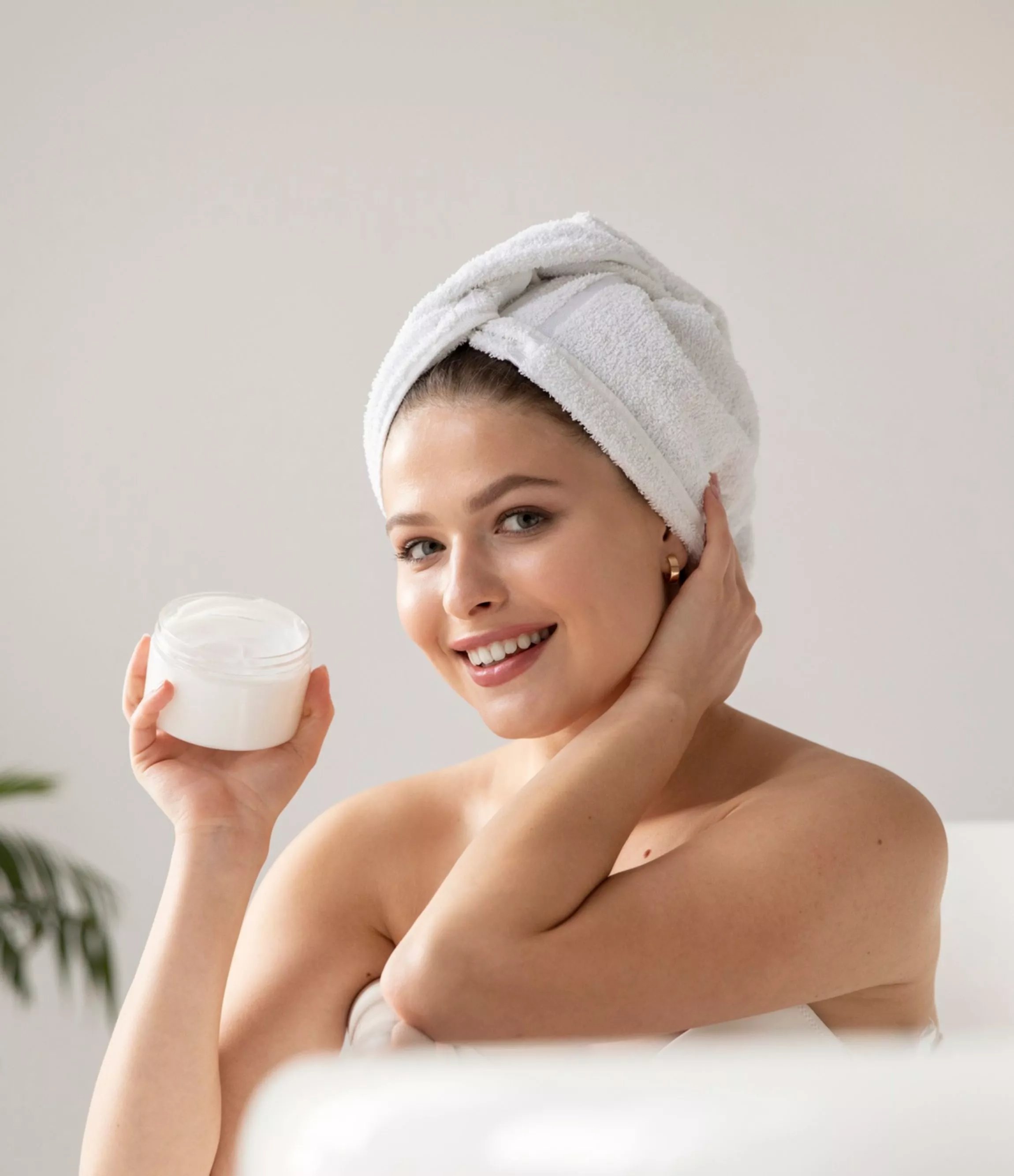 girl in the bathroom with a towel on her head and a jar of cream in her hands