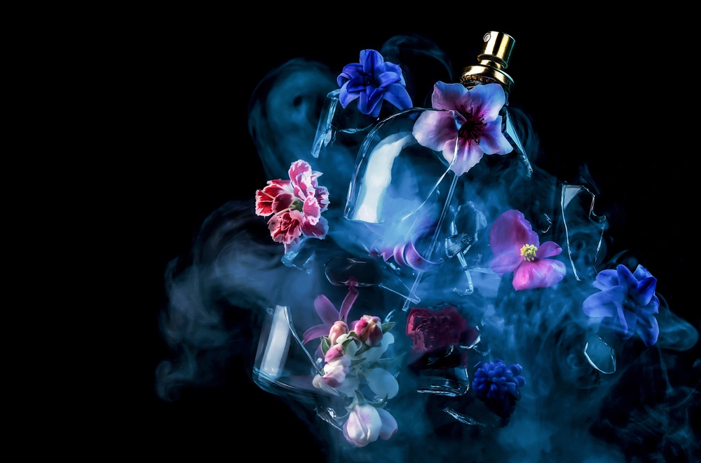 a bottle of perfume in the haze from which flowers can be seen