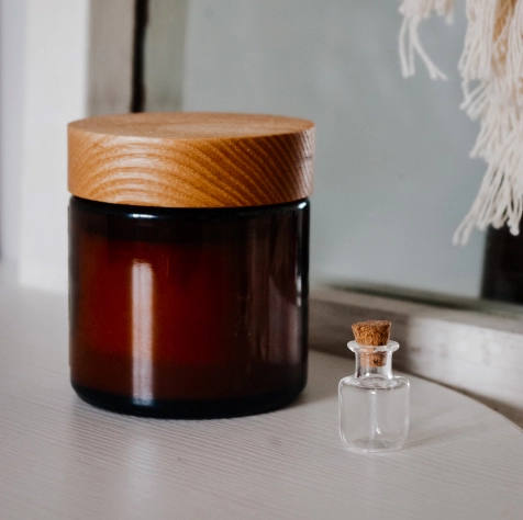 small transparent glass bottle on the background of a large jar