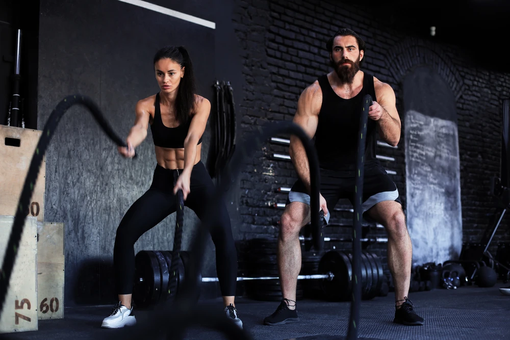 guy and girl working out with ropes